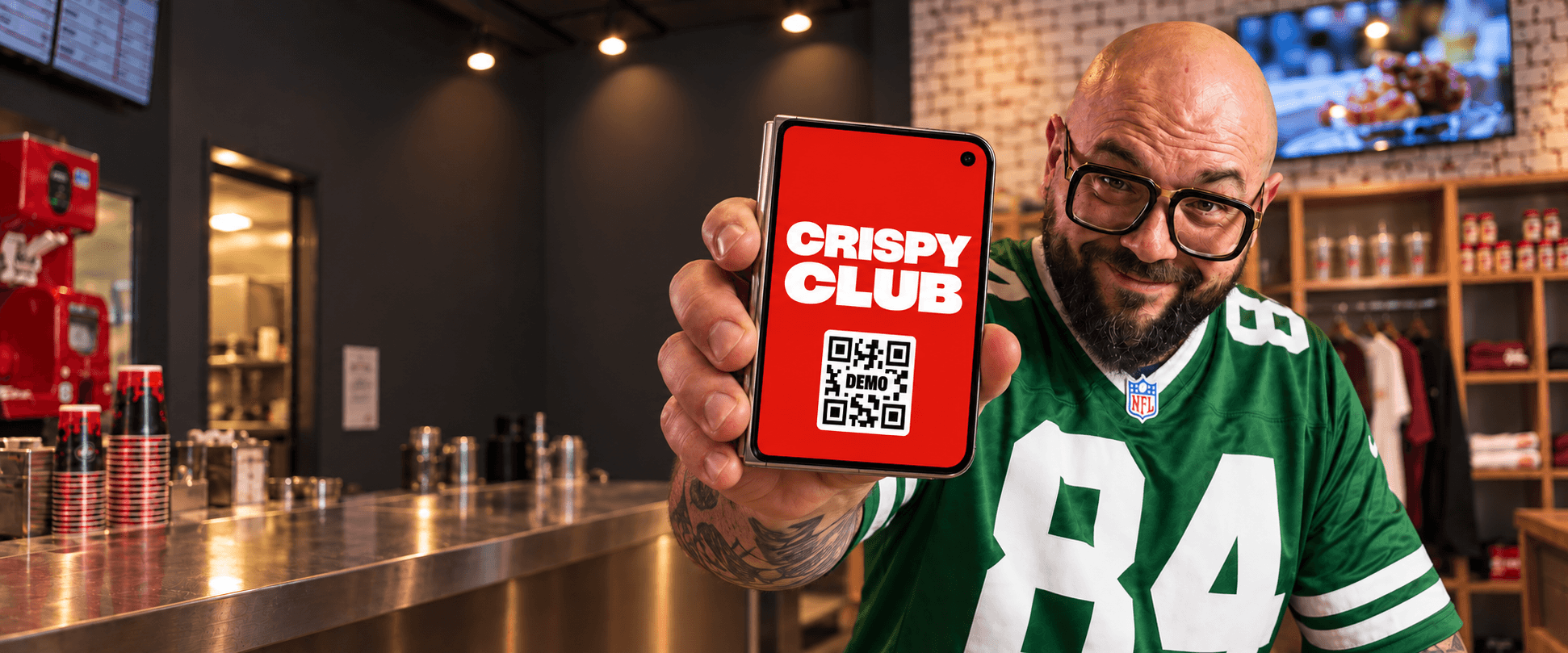 Mocho mostra in primo piano un iPhone con la tessera dimostrativa del Crispy Club, nello store di via Melzo.